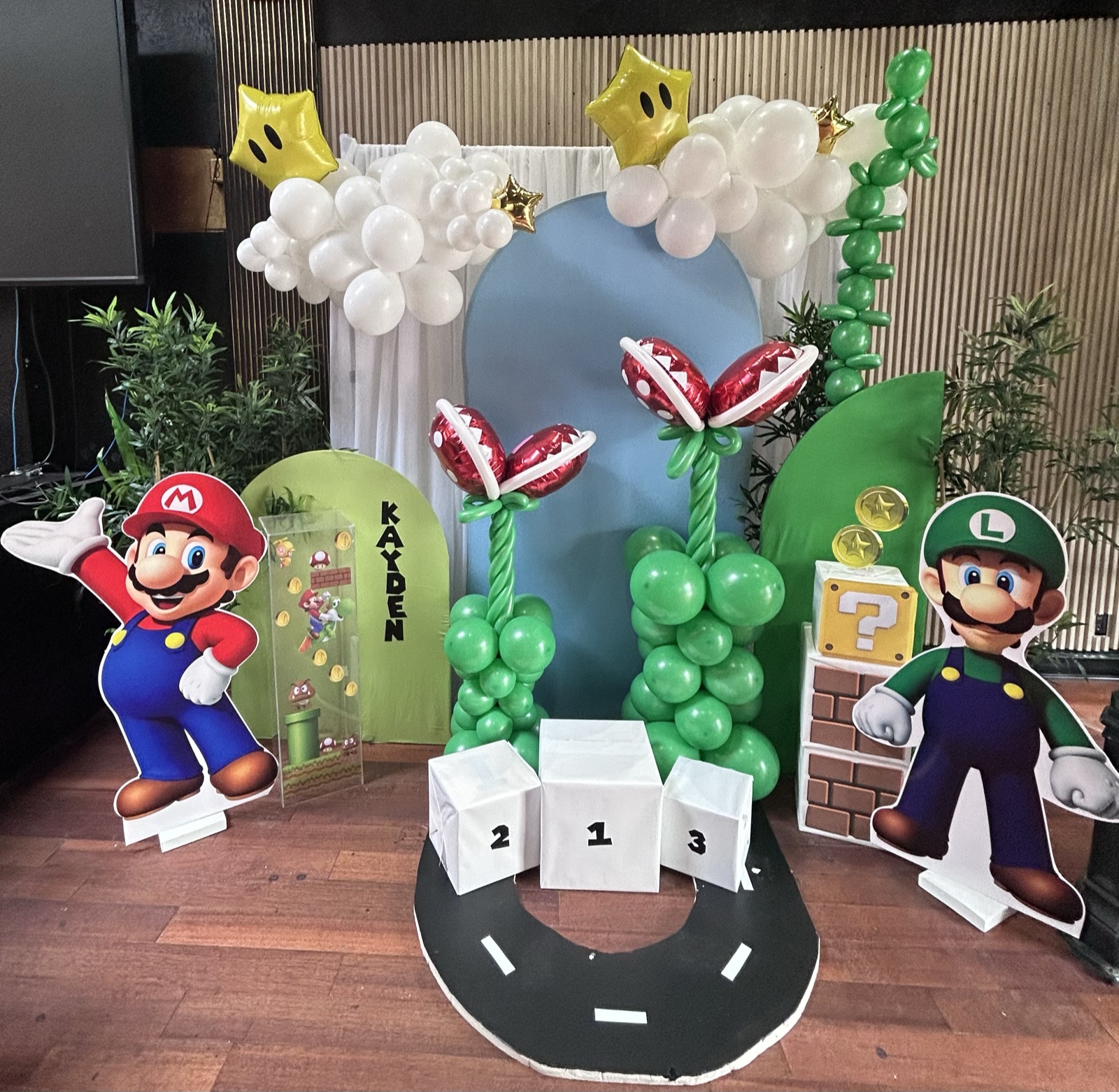 A video-game themed children's party with a balloon arch and character cutouts