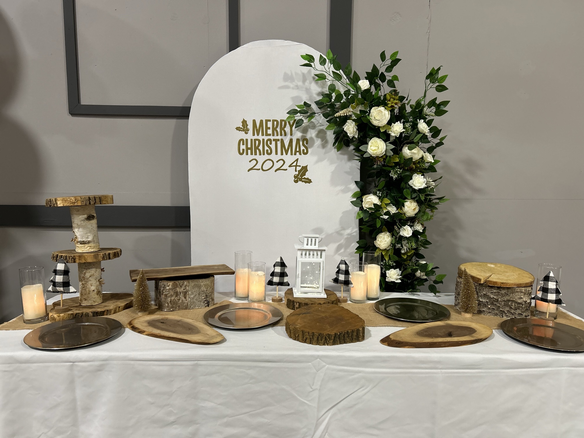 A Christmas dessert and grazing table beneath a floral arch