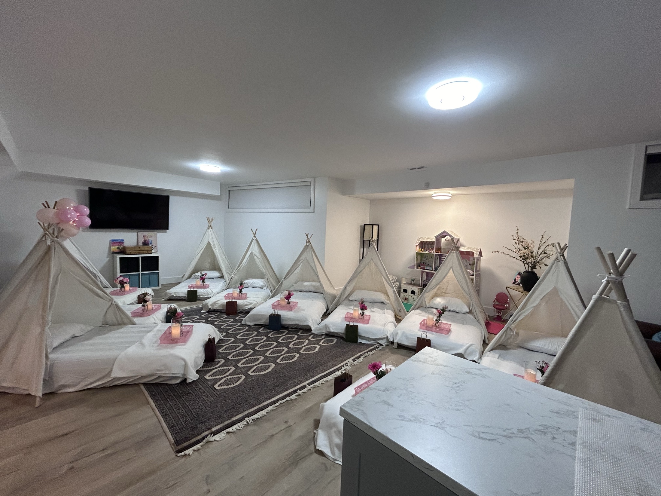 A row of sleepover tents made up with bedding and cushions